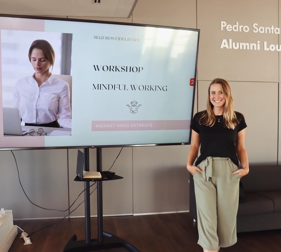 Isabel presenting at Fidelidade next to the Mindful Working workshop slide